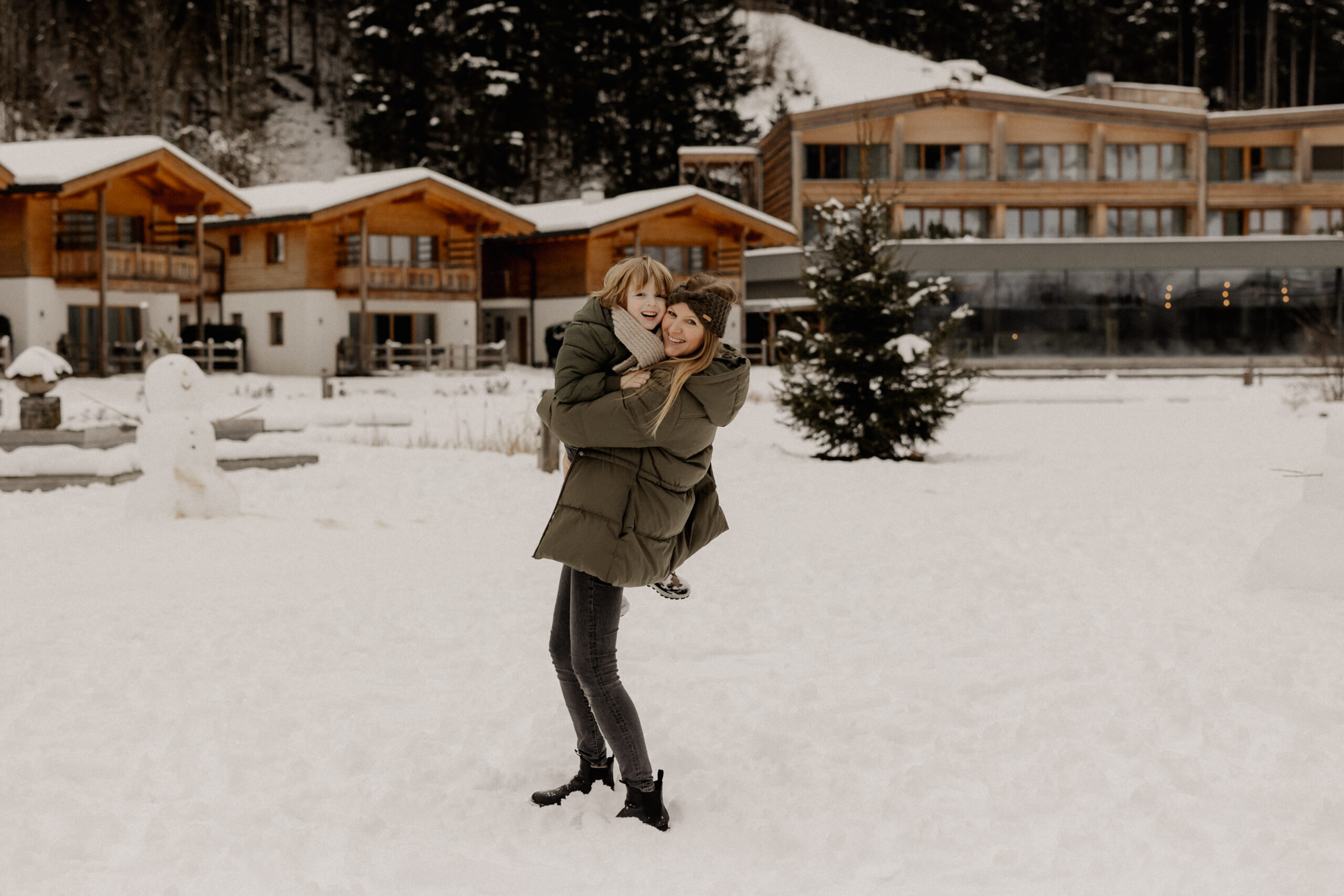 Hochzeitsfotografen Kathi Chris Mutter hält Kind hoch Schnee