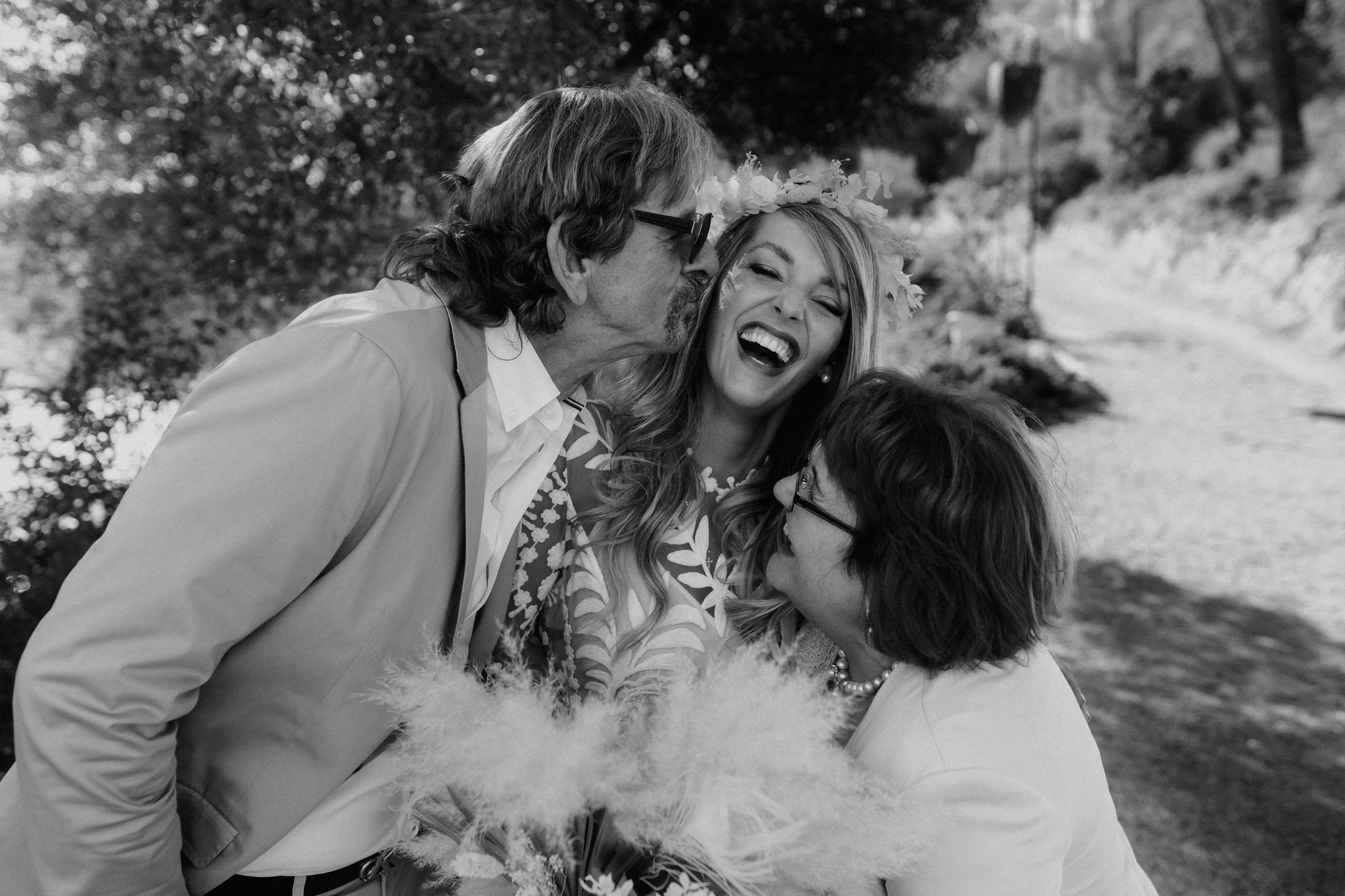 Hochzeitsreportage Mallorca Brauteltern küssen Braut und lachen